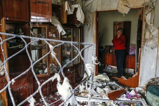 A woman reacts as she looks at the debris inside a flat at a residential block damaged by a recent shelling in Yenakieve town, northeast from Donetsk, February 2, 2015. (Photo by Maxim Shemetov/Reuters)