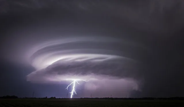 A lightning bolt emerges from a severe thunderstorm just west of Wichita, Kan., on Tuesday, June, 26, 2018. Multiple storms erupted over south-central Kansas on Tuesday. (Photo by Travis Heying/The Wichita Eagle via AP Photo)
