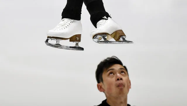Yang Jin from China watches his partner Cheng Peng jumping during a practice session of the pairs at the Figure Skating World Championships in Stockholm, Sweden, Tuesday, March 23, 2021. (Photo by Martin Meissner/AP Photo)