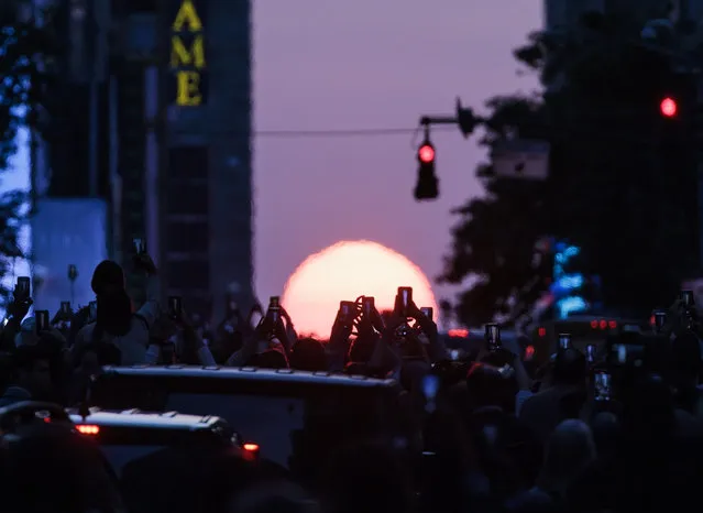 People watch the sunset down 42nd Street during “Manhattanhenge”, when the sunset aligns with the city's streets, in New York, New York, USA, 30 May 2023. (Photo by Justin Lane/EPA/EFE/Rex Features/Shutterstock)