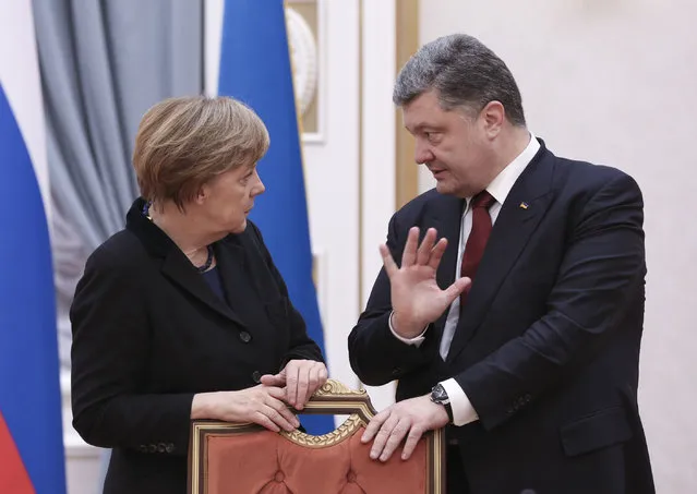 German Chancellor Angela Merkel and Ukrainian President Petro Poroshenko talk in Minsk, Belarus, Wednesday, February 11, 2015. (Photo by Mykhailo Palinchak/AP Photo)