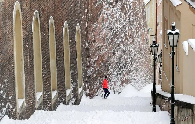 A woman exercises on snow-covered stairs of the Prague Castle in Prague, Czech Republic, February 8, 2021. (Photo by David W. Cerny/Reuters)