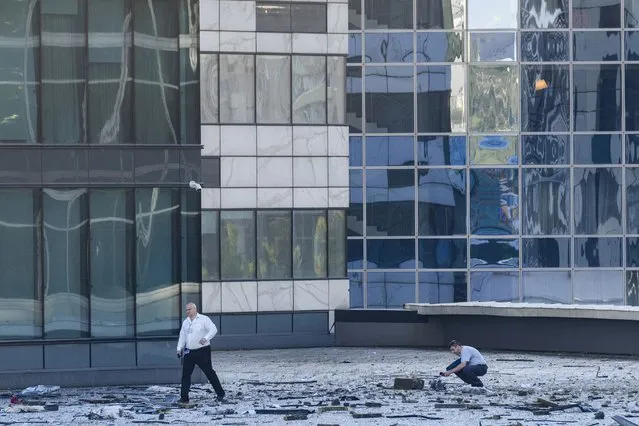 Investigators examine an area next to a damaged building in the “Moscow City” business district after a reported drone attack in Moscow, Russia, early Tuesday, August 1, 2023. Ukrainian drones again targeted Moscow and its surroundings early Tuesday morning, the Russian military reported. Two of three launched were shot down outside Moscow, while one crashed into a skyscraper in the Moscow City business district, damaging the building’s facade. (Photo by AP Photo/Stringer)