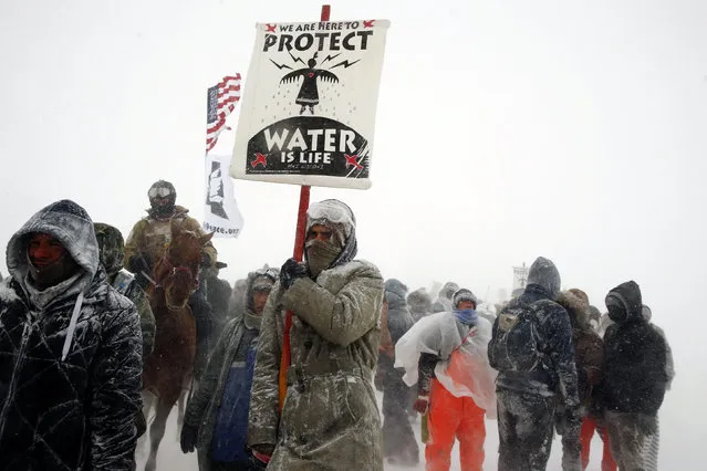 Veterans join activists in a march just outside the Oceti Sakowin camp during a snow fall as “water protectors” continue to demonstrate against plans to pass the Dakota Access pipeline adjacent to the Standing Rock Indian Reservation, near Cannon Ball, North Dakota, U.S., December 5, 2016. (Photo by Lucas Jackson/Reuters)