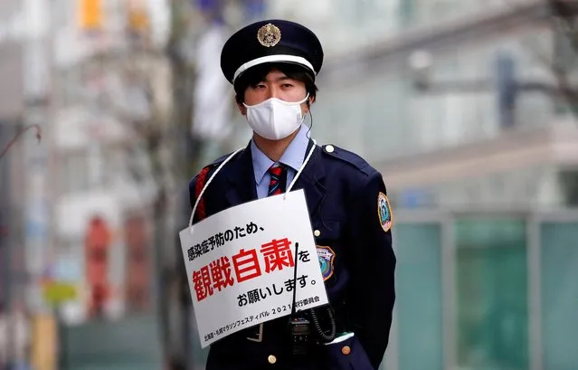 A member of the security personnel wears a sign that reads “In order to prevent infection, please refrain from watching”, along the route before the start of the Hokkaido-Sapporo Marathon Festival 2021, a half-marathon and a 10K race which is a test event for the Tokyo 2020 Olympics marathon race, amid the coronavirus disease (COVID-19) outbreak, in Sapporo, Hokkaido, Japan on May 5, 2021. (Photo by Issei Kato/Reuters)