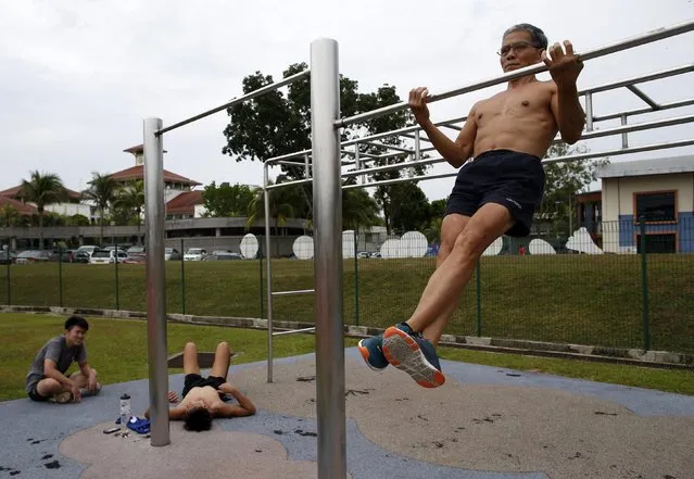 Ngai Hin Kwok, 66, part of a trio of senior citizens who train in calisthenics, works out at a stadium next to youths at a stadium in Singapore March 15, 2015. (Photo by Edgar Su/Reuters)