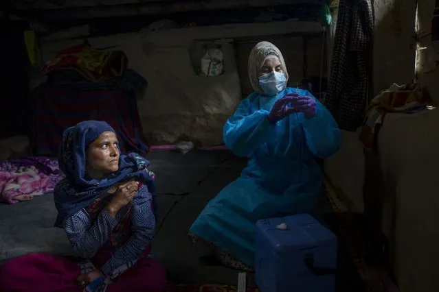 Masrat Farid, a healthcare worker, prepares to administers a dose of Covishield vaccine to Rubia Begum inside a hut during a COVID-19 vaccination drive in Gagangeer, northeast of Srinagar, Indian controlled Kashmir on June 22, 2021. Farid has traveled to long distances for vaccinating mostly shepherds and nomadic herders in the remote meadows of the Himalayan region of Indian-controlled Kashmir. Her challenge has not been the treacherous terrain but to persuade women to get COVID-19 vaccines. “Everywhere we go it seems rumors reach earlier than we do, and it makes our job difficult”, Farid said recently during a vaccination campaign at a high altitude meadow. (Photo by Dar Yasin/AP Photo)