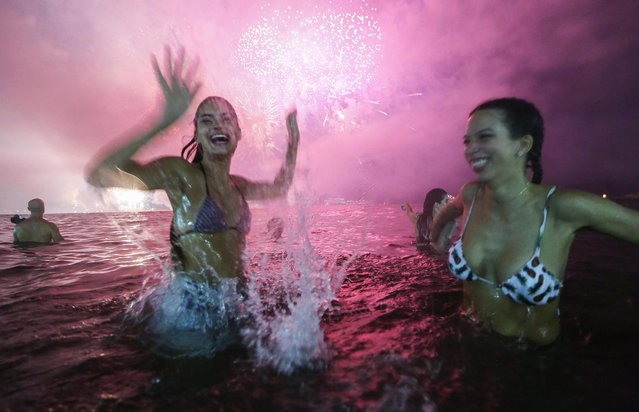 Revelers celebrate during fireworks marking the start of the New Year on Copacabana beach on January 1, 2017 in Rio de Janeiro, Brazil. (Photo by Mario Tama/Getty Images)