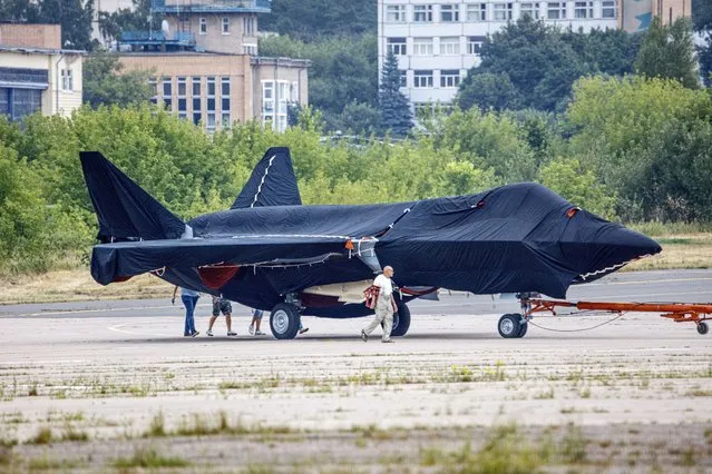 Hidden under tarpaulin, a prospective Russian fighter jet is being towed to a parking spot before its presentation at the Moscow international air show in Zhukovsky outside Moscow, Russia, Thursday, July 15, 2021. Russian aircraft makers say they will present a prospective new fighter jet at a Moscow air show that opens next week. The new warplane hidden under tarpaulin was photographed being towed to a parking spot across the airfield in Zhukovsky outside Moscow. That's where MAKS-2021 International Aviation and Space Salon opens on Tuesday. Russian President Vladimir Putin is set to visit the show’s opening. (Photo by Ivan Novikov-Dvinsky/AP Photo)
