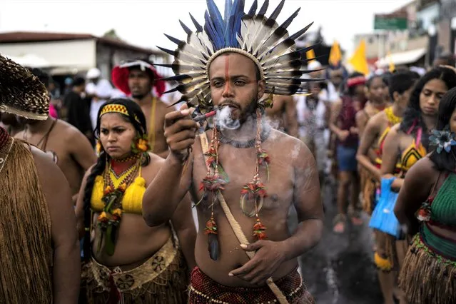 People with Indigenous roots in the Salvador region, Bahia State, march during a protest in Salvador, Brazil, Sunday, September 18, 2022. The dunes are a traditional place for members of Afro-Brazilian religions to leave offerings, especially at the Abaete Lake, and protesters called on authorities to take action against a series of environmental offenses in the area they consider sacred. (Photo by Rodrigo Abd/AP Photo)