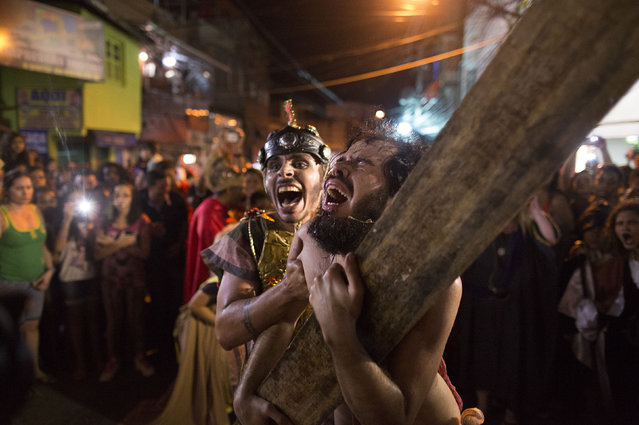 Actor Lucas Valentim, right, plays the role of Jesus during the a Passion of Christ procession on Good Friday during Holy Week in the Rocinha slum of Rio de Janeiro, Brazil, Friday, April 3, 2015. Holy Week commemorates the last week of the earthly life of Jesus Christ culminating in his crucifixion on Good Friday and his resurrection on Easter Sunday. (Photo by Leo Correa/AP Photo)