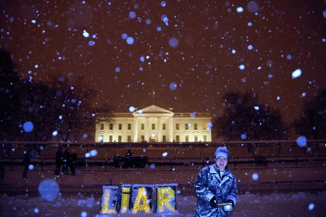 A protester stands outside of the White House during winter storm Gia as the partial government shutdown becomes the longest in U.S. history in Washington, U.S., January 13, 2019. (Photo by Carlos Barria/Reuters)