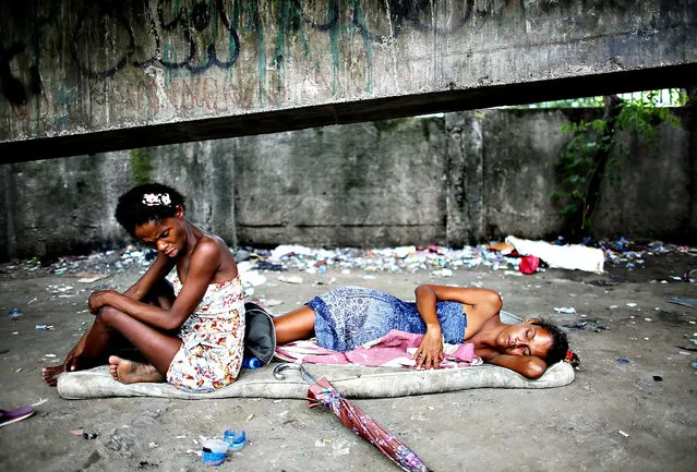 Drug users gather beneath an overpass in an area known as “Cracolandia”, or Crackland, in the Antares shantytown on December 10, 2013 in Rio de Janeiro, Brazil. According to the Economist, recent studies have shown Brazil to be the world's largest crack market, with 1-1.2 million users. The use of crack has rapidly expanded and become a nationwide epidemic largely due to Brazil's proximity to cocaine-producing countries and an increase in purchasing power within the country. (Photo by Mario Tama/Getty Images)