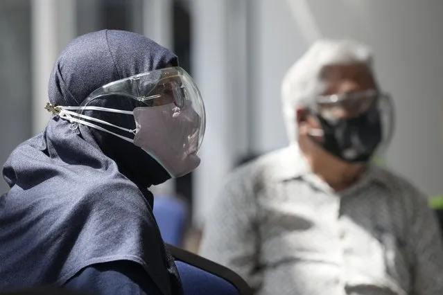 A Muslim couple wearing face mask and face shield while waiting for vaccine for the coronavirus disease (COVID-19) at a vaccination centre in Kuala Lumpur, Malaysia, Monday, May 31, 2021. An exhibition center in Malaysia has been turned into the country's first mega vaccination center as the government aims to speed up inoculations amid a sharp spike in infections. (Photo by Vincent Thian/AP Photo)