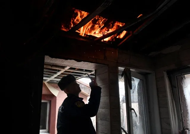 A rescuer takes pictures inside a damaged residential building hit by recent shelling in the course of Russia-Ukraine conflict in Donetsk, Russian-controlled Ukraine on November 30, 2023. (Photo by Valery Melnikov/Reuters)