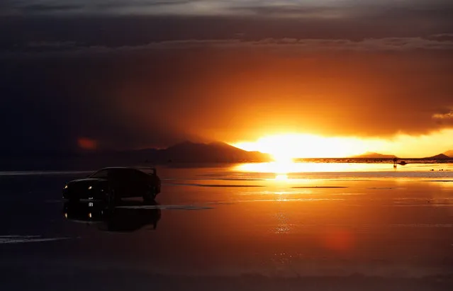 A car is pictured as the sun sets over the Salar de Uyuni or Uyuni Salt Flat during Day 7 of the 2014 Dakar Rally on January 11, 2014 in Uyuni, Bolivia. (Photo by Dean Mouhtaropoulos/Getty Images)
