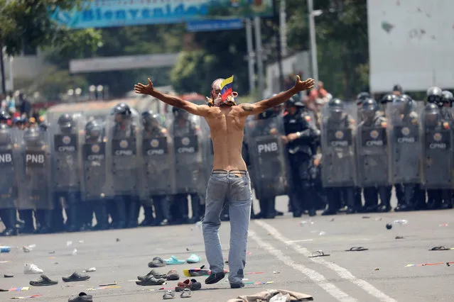 A Venezuelan opposition demonstrator gestures towards Venezuela's security forces at Simon Bolivar bridge on the border line between Colombia and Venezuela as seen from Cucuta, Colombia February 23, 2019. (Photo by Edgard Garrido/Reuters)