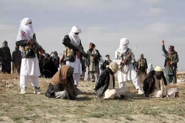 Taliban insurgents stand over three men, accused of murdering a couple during a robbery, before shooting them during their execution in Ghazni Province April 18, 2015. The Taliban announced the execution of the three men accused of murdering a couple during a robbery, saying they had been tried by an Islamic court. (Photo by Reuters/Stringer)
