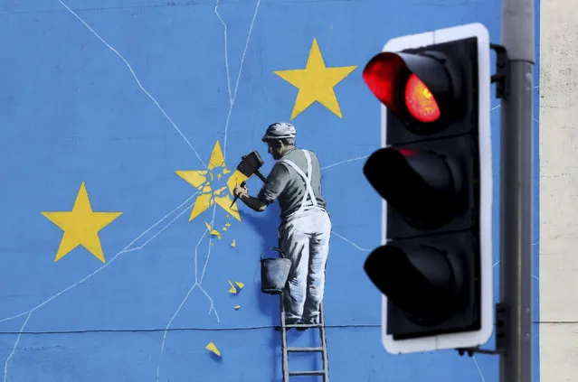 A view of the Banksy Brexit mural of a man chipping away at the EU flag in Dover, England, Tuesday, December 11, 2018. Top European Union officials on Tuesday ruled out any renegotiation of the divorce agreement with Britain, as Prime Minister Theresa May fought to save her Brexit deal by lobbying leaders in Europe's capitals. (Photo by Gareth Fuller/PA Wire via AP Photo)