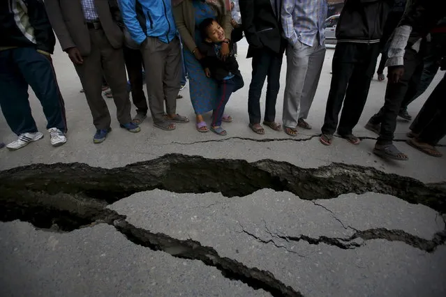 People gather near the cracks on the road caused by an earthquake in Bhaktapur, Nepal April 26, 2015. (Photo by Navesh Chitrakar/Reuters)