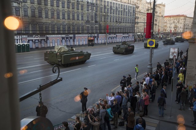 New Russian military vehicles making their way to Red Square are photographed through a cafe window during a rehearsal for the Victory Day military parade which will take place at Moscow's Red Square on May 9 to celebrate 70 years after the victory in WWII, in Moscow, Russia, Wednesday, April 29, 2015. (Photo by Alexander Zemlianichenko/AP Photo)