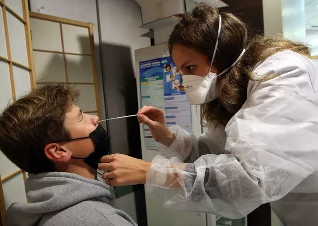 A pharmacist collects a nasal swab sample for a COVID-19 test in a pharmacy in Bayonne, southwestern France, Friday, October 15, 2021. COVID-19 tests in France are no longer free for unvaccinated adults unless they are prescribed by a doctor. While tests remain free for vaccinated adults and all children under 18, adults who have not gotten their shots will have to pay 22-45 euros ($25-$52) to get tested as of Friday. (Photo by Bob Edme/AP Photo)