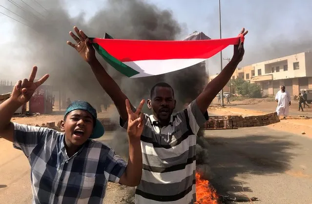 A protester waves a flag during what the information ministry calls a military coup in Khartoum, Sudan, October 25, 2021. (Photo by Mohamed Nureldin Abdallah/Reuters)