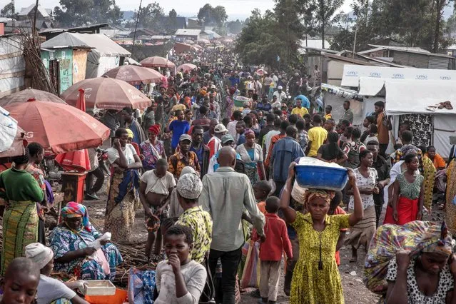 Displaced people go about their daily business west of the town of Goma, eastern Democratic Republic of Congo, on February 16, 2024. The conflict between M23 rebels and government forces has intensified in Masisi territory in recent weeks, causing many displaced people to move around Goma without shelter or food, leaving everything behind. (Photo by Guerchom Ndebo/AFP Photo)