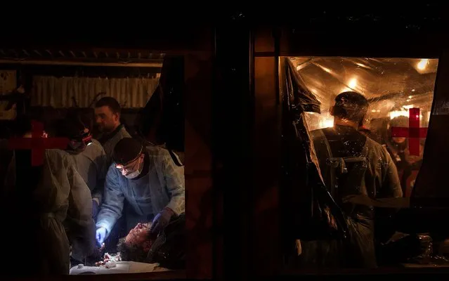 Medical volunteers treat a wounded man in a makeshift medical tent at the protest camp in Independence Square in Kiev, on February 19, 2014. (Photo by Sergey Ponomarev/The New York Times)