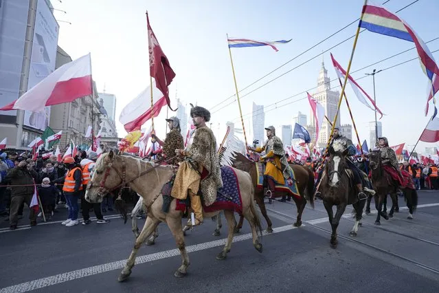 Riders wearing historic outfits take part the annual Independence Day march which turned violent in recent years because of the participation of right-wing groups, in Warsaw, Poland, on Thursday, November 11, 2021. The Warsaw mayor and courts banned this year's event due to its history of violence, but the right-wing ruling authorities defied the ban and gave the march state event status to allow it to go ahead. (Photo by Czarek Sokolowski/AP Photo)