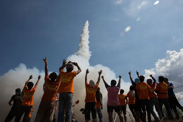 Thai men cheer as their rocket takes off at the Bun Bang Fai Rocket Festival on May 10, 2015 in Yasothon, Thailand. (Photo by Taylor Weidman/Getty Images)