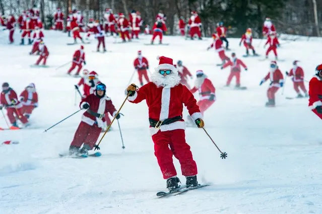 Skiers and snowboarders take part in the annual Santa Ski Run on Santa Sunday at Sunday River in Newry, Maine, on December 5, 2021. Over 200 participants took part in the event and helped raise $4,640 for the non profit group River Fund Maine which supports local youth in the area. (Photo by Joseph Prezioso/AFP Photo)