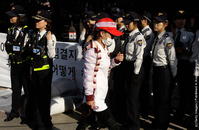 A South Korean prostitute walks in front of police