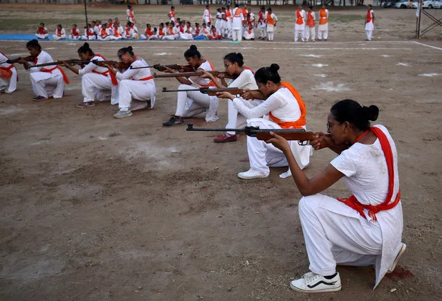 Members of Durga Vahini, the women's wing of Vishva Hindu Parishad (VHP), a Hindu nationalist organisation, show their self-defence skills with firearms at the concluding ceremony of a weeklong women's training camp on the outskirts of Ahmedabad, India on May 25, 2019. (Photo by Amit Dave/Reuters)