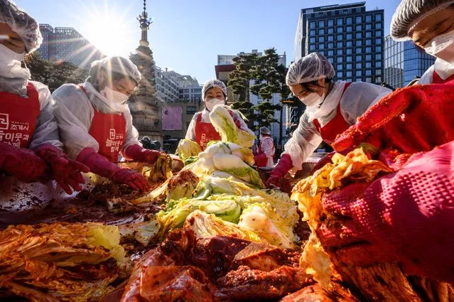 Participants prepare kimchi, a traditional Korean dish of spicy fermented cabbage and radish, during a kimchi making festival at the Jogyesa Buddhist temple in Seoul on December 2, 2021, before it is distributed among the less privileged from the local neighbourhood. (Photo by Anthony Wallace/AFP Photo)