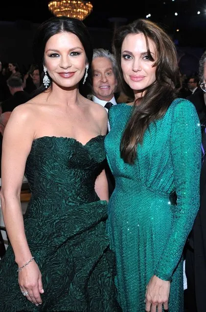 Michael Douglas with gorgeous girls in green. Catherine Zeta-Jones and Angelina Jolie at Golden Globe Awards in 2011. (Photo by Vince Bucci/Getty Images)