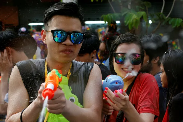 Revellers react during a water fight at Songkran Festival celebrations in Bangkok April 13, 2016. (Photo by Jorge Silva/Reuters)