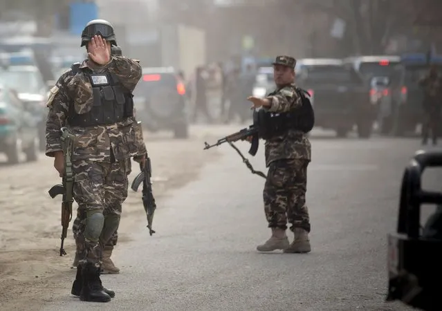 Commandos with Afghanistan's intelligence agency arrive after four suicide bombers armed with assault rifles and hand grenades attacked an “office of foreigners” in a southwestern neighborhood of Kabul, March 28, 2014. A Taliban spokesman said insurgents attacked a “guest house of foreigners and a church of foreigners”. (Photo by Anja Niedringhaus/AP Photo)