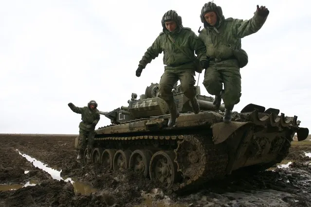 Russian soldiers jump from their tank during military exercises in the southern Russia's Volgograd region, on April 2, 2014. Russian troops deployed close to the Ukrainian border will return to base after completing their exercises, Foreign Minister Sergei Lavrov said today. NATO said yesterday it had stepped back from a floated idea to reinforce the alliance's military presence in countries bordering Russia, preferring for now to suspend cooperation with Moscow and give more time to talks. (Photo by Andrey Kronberg/AFP Photo)