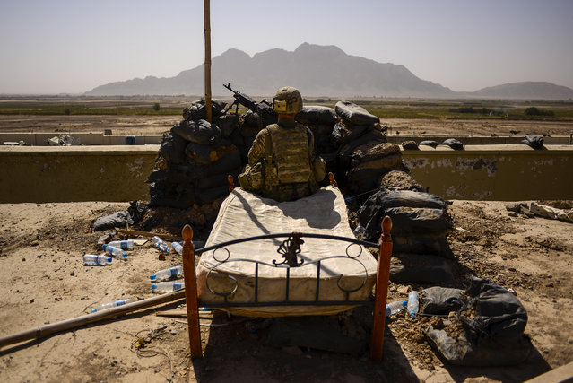 Spc. Derek Smith, a gunner with the 2nd Cavalry Regiment, pulls security from the roof of the Panjwai District headquarters in Southern Afghanistan's Kandahar Province, Saturday, October 5, 2013. (Photo by Air Force Tech. Sgt. Joshua L. DeMotts/Stars and Stripes)