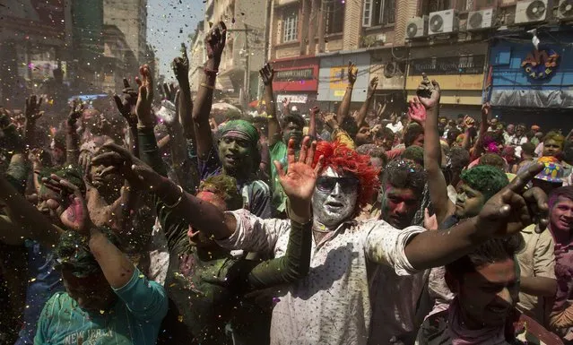 Indians with faces smeared in color dance during the Holi celebrations in Gauhati, India, Monday, March 13, 2017. (Photo by Anupam Nath/AP Photo)