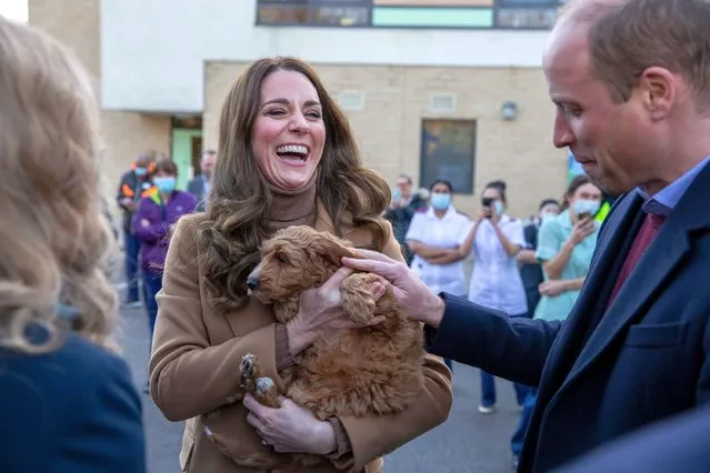 Britain's Catherine, Duchess of Cambridge, watched by her husband Britain's Prince William, Duke of Cambridge, holds a therapy puppy, before unveiling it's name, Alfie, to members of staff during their visit to Clitheroe Community Hospital in north east England on January 20, 2022. The puppy, funded through the hospital charity ELHT&Me using a grant from NHS Charities Together, will be used to support the wellbeing of staff and patients at the hospital. (Photo by James Glossop/Pool via AFP Photo)