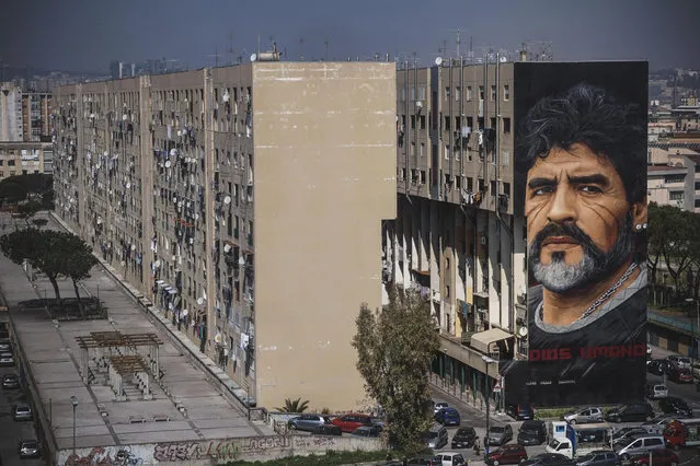 A huge mural by Italian artist Jorit Agoch, depicting former Argentinian soccer player Diego Armando Maradona, is seen on a building of the San Giovanni a Teduccio neighborhood in Naples, Italy, 21 March 2017. (Photo by Cesare Abbate/EPA)