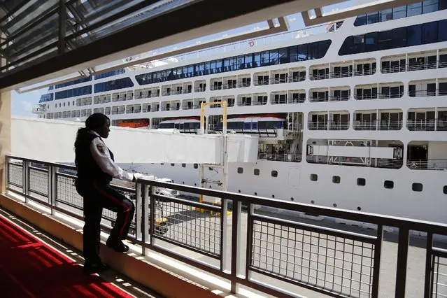 Security agent looks over towards the Carnival Crop.'s Adonia as passengers board before it leaves port in Miami, Sunday, May 1, 2016, en route to Cuba. After a half-century of waiting, passengers finally set sail on Sunday from Miami on an historic cruise to Cuba. Carnival's Cuba cruises, operating under its Fathom band, will visit the ports of Havana, Cienfuegos and Santiago de Cuba. (Photo by Carl Juste/The Miami Herald via AP Photo)