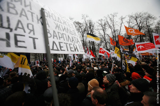 Protesters hold flags and banners aloft as they march in Bolotnaya Square on December 10, 2011 in Moscow, Russia