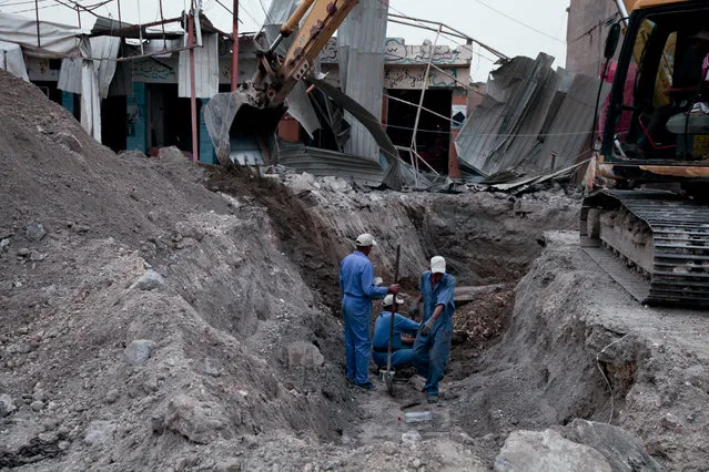 Iraqi workers dig a trench for a new water pipe near Haji Ziad square in the center of Ramadi on March 20, 2016. Months after the city was freed from Islamic State group control, reconstruction has hardly begun in Ramadi, where entire city blocks were leveled and infrastructure was smashed in months of fighting, illustrating the giant task Iraq will face as it recaptures more cities from the extremists. (Photo by Maya Alleruzzo/AP Photo)