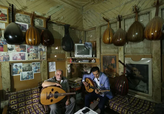 In this photo taken Thursday, June 18, 2015, Bassam Salim, right, and Mahmoud Abdulnabi , left,  play on ouds at Abdulnabi's workshop in Baghdad, Iraq. The Islamic State group has banned music in the third of Iraq under its control, but in Baghdad a growing number of musicians and other artists are defying the extremists, hoping to revive a rich culture smothered by decades of war. (Photo by Hadi Mizban/AP Photo)