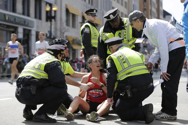 Skye Taylor, of Columbus, Ohio, is assisted by Boston Police officers after collapsing near the end the 118th Boston Marathon Monday, April 21, 2014 in Boston. (Photo by Robert F. Bukaty/AP Photo)
