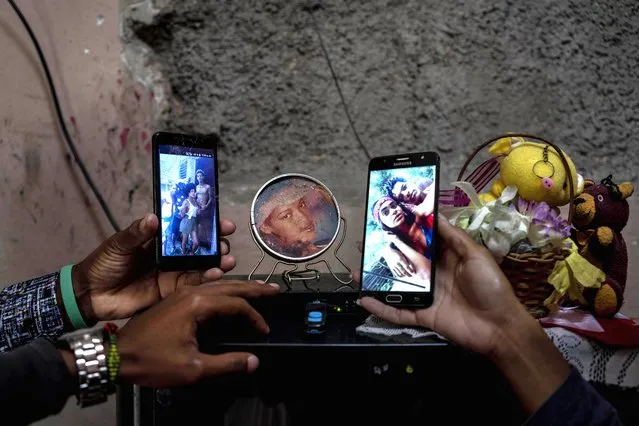 Relatives show photos of the three Roman siblings who are in prison accused of participating in anti-government protests, at their home in the La Guinera neighborhood of Havana, Cuba, Wednesday, January 19, 2022. Six months after surprising protests against the Cuban government, more than 50 protesters charged with sedition are headed to trial and could face prison sentences up to 30 years. (Photo by Ramon Espinosa/AP Photo)
