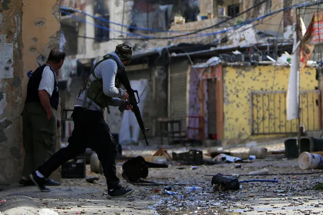 A Palestinian Fatah gunman carries his weapon and he attempts to cross a street at the Ain el-Hilweh refugee camp near Sidon, southern Lebanon April 10, 2017. (Photo by Ali Hashisho/Reuters)